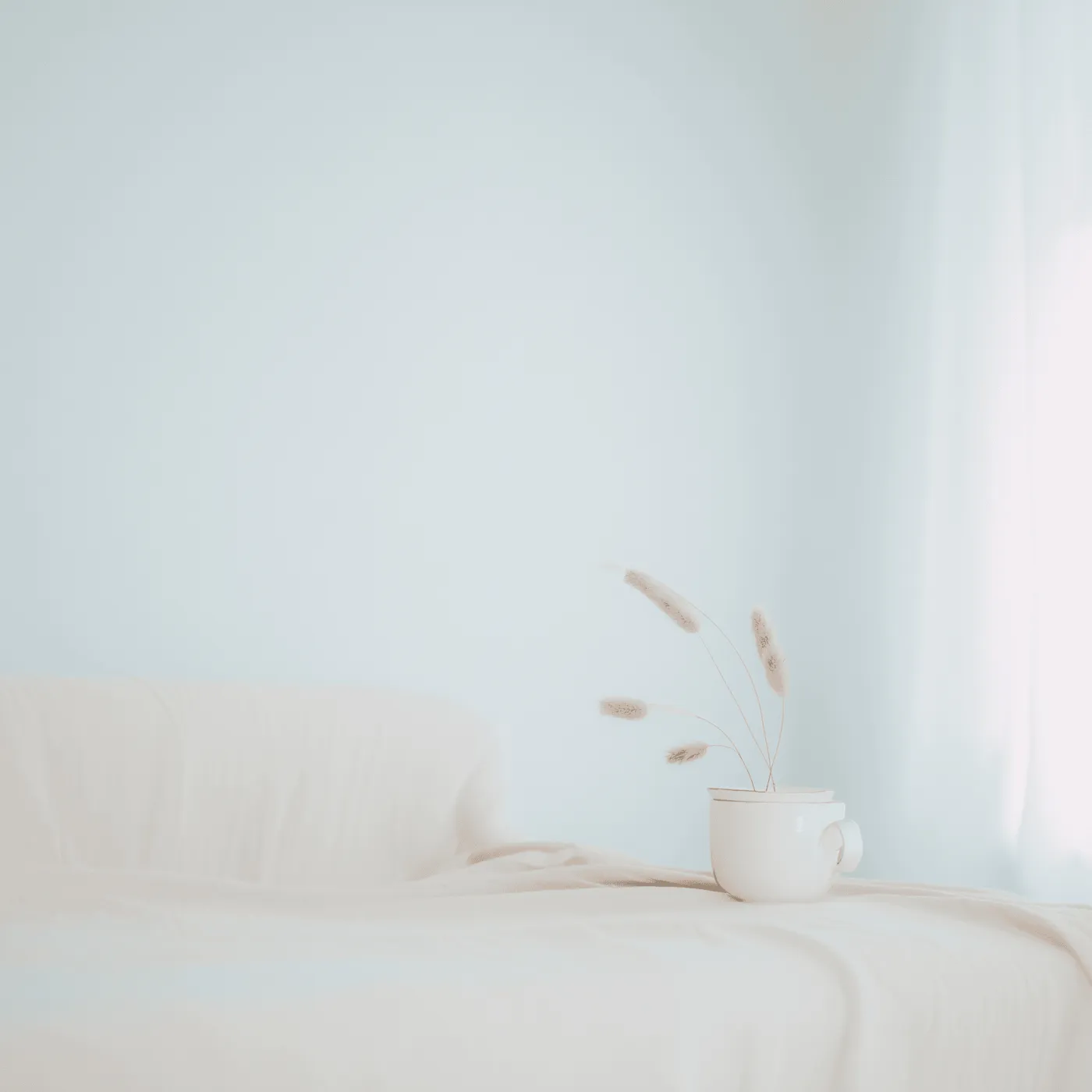 Heller, ruhiger Raum mit Tasse und Trockenblumen